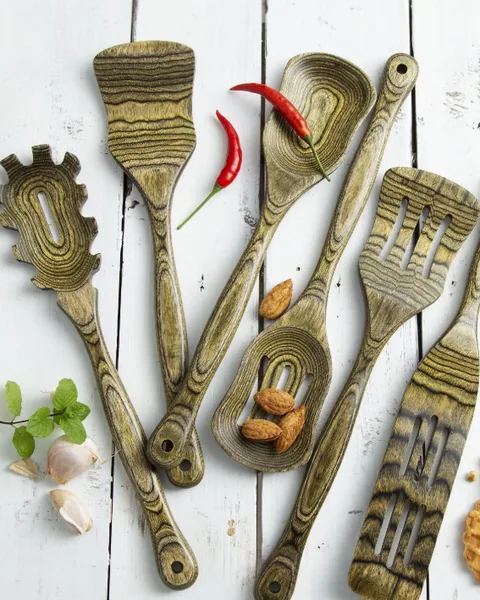 Six layered-wood cooking utensils laid out on white boards